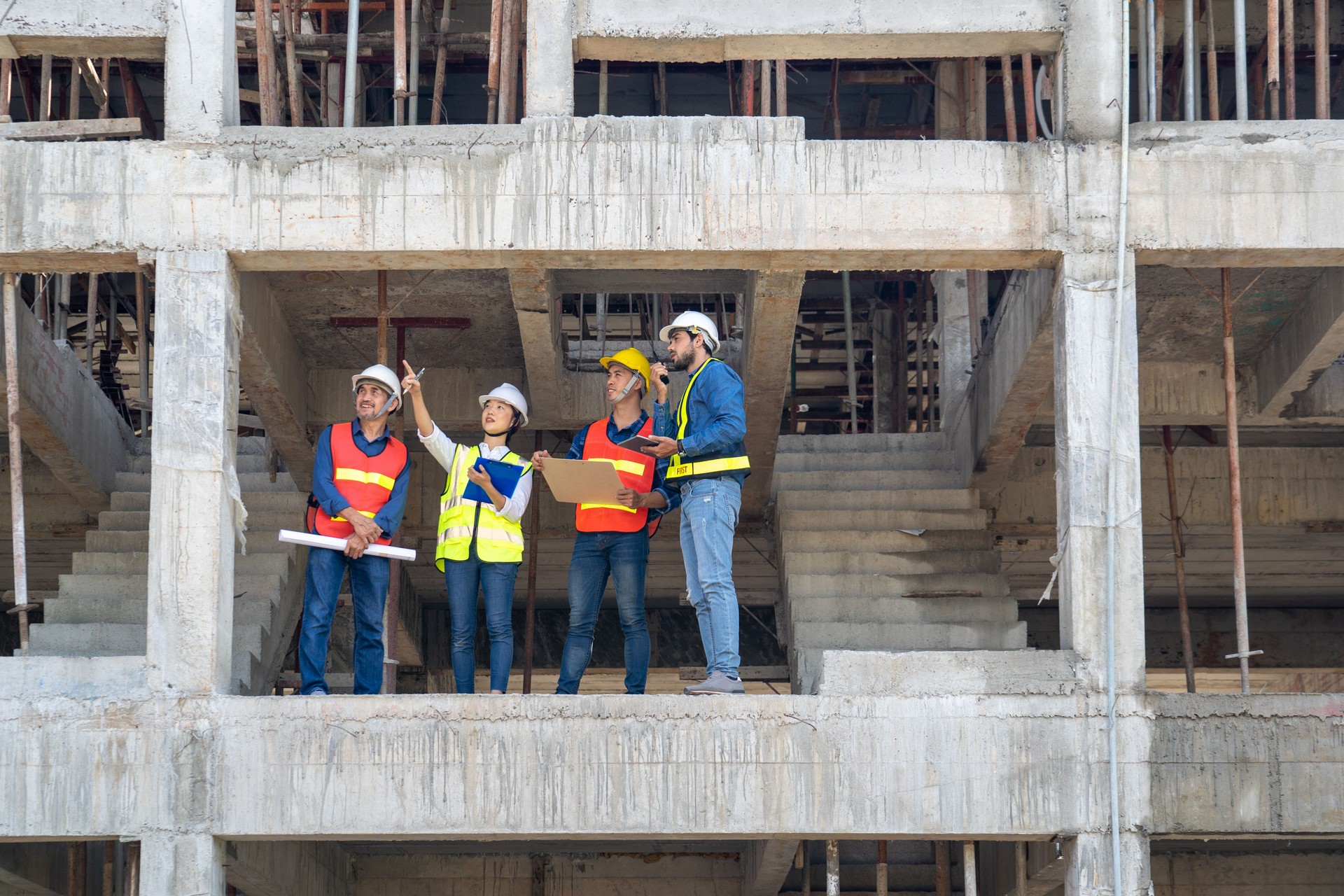 team of civil engineer together with safety operator inspect the infrastructure of building construction progress at site