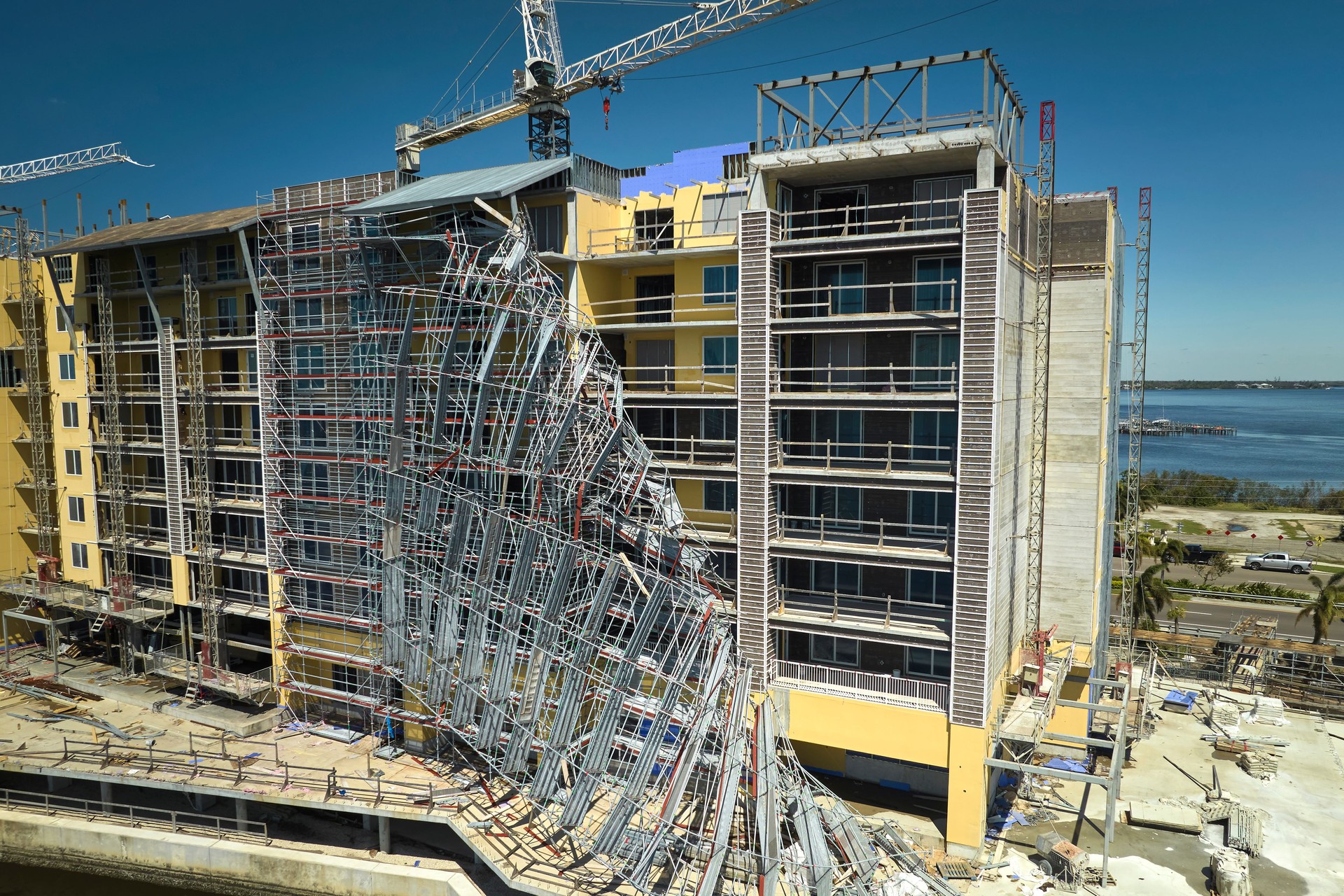 Aerial view of ruined by hurricane Ian construction scaffolding on high apartment building site in Port Charlotte, USA